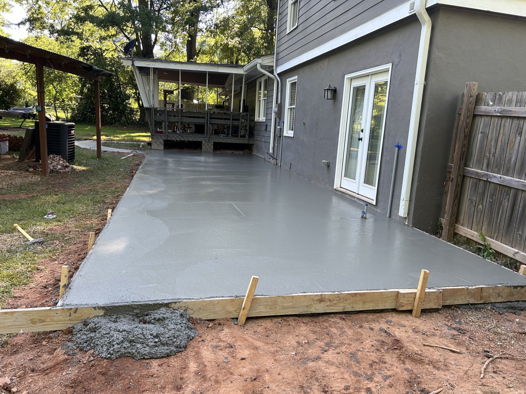 Finished rear patio and concrete walkway around a Georgia home